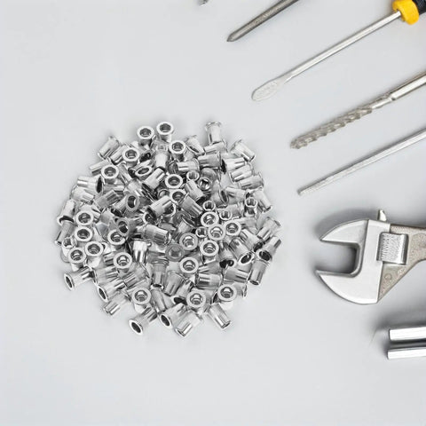 Stainless Steel Rivet Nuts Kit With 120 Pieces Flat Head Knurled Threaded Inserts on a table with tools
