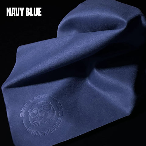 Front view: navy blue microfiber lens cleaning cloth with embossed See Lion logo; reusable for glasses and screens