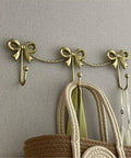 Kickass Heavy Duty Wall Mounted Coat Hook Bulletproof Metal Clothes Hanger with decorative bows holding bags.