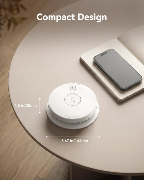 No Sweat Setup Photoelectric Smoke Detector And Hardwired Fire Alarm With Interconnected Wiring And 9V Backup on a table beside a smartphone.