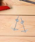 Close-up of Heavy Duty Toggle Bolts And Wing Nut Kit 15 Sets Carbon Steel Wall Anchors on wood surface with tools.