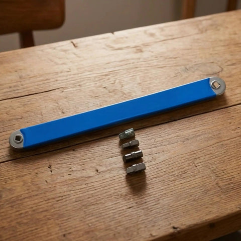 Badass Offset Extension Wrench With Swappable Drive Adapters And Quick Socket Attachments Built From Tough High Carbon Steel No Hustle Multi Tool For Cramped Spaces Or Gunked Up Bolts Orange, blue handle with adapters on a wood table.