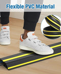 Person stepping on Heavy Duty PVC Cord Cover Protector 10 ft Floor Cable Duct That Unrolls Easily Prevents Trip Hazards.