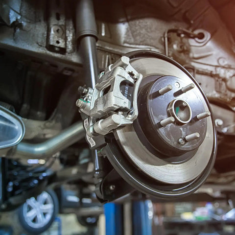 Close-up of a car brake system featuring heavy-duty brake caliper and rotor. Ideal for vehicle maintenance and upgrade.