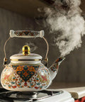 Floral Enamel Tea Kettle With Ceramic Handle Two And A Half Liter Capacity Vintage Gold Beige Boho Porcelain Teapot on stovetop