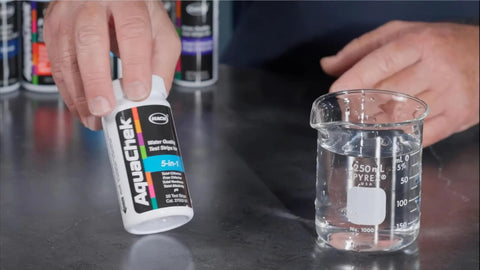 Real Down To Earth Five In One Water Quality Test Strips For Pools And Spas in hand with water sample in beaker.