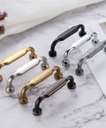 Premium Solid Metal Brushed Gold Cabinet Pulls, Heavy Duty Footed Drawer Handles in various finishes on stone surface.
