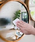 Hand using Premoistened Screen Cleaning Wipes For Electronics And Devices No Mess Easy Cleanup on a mirror surface