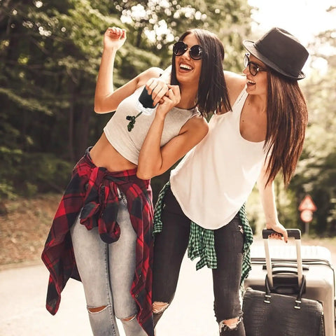 Two people traveling with suitcases, enjoying nature and adventure outdoors, representing a sense of freedom and exploration.