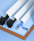 Self Adhesive Cable Hider For Tidy Workspace Vibes And Durable Pvc Wire Cover with electrical plugs neatly organized in channels.