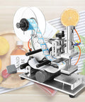 Rock Solid Semi Automatic Plane Labeling Machine With Adjustable Applicator For Flat Bottles applying labels in a kitchen setting.