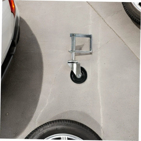 Badass 4 Inch Rubber Gate Wheel Caster Featuring An Adjustable Spring Bracket mounted on concrete surface near vehicle tire.