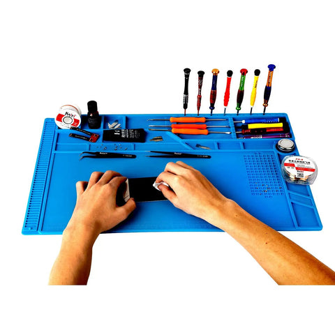 Hands using Pro Grade Large Silicone Soldering Mat With Magnetic Parts Layout Built In Ruler for Electronics Computer Repair 21.6 By 13.8 Inches Heat Resistant Insulation Soldering Station Pad With 124 Screw Positions 4 Magnetic Areas 18 Notches 49 Spare Units surrounded by tools on blue mat