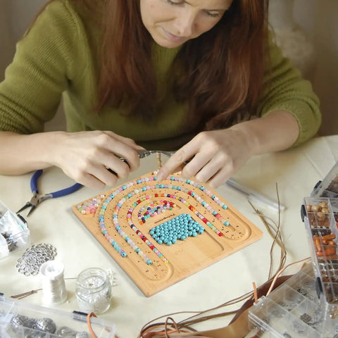 Person using Bamboo Bead Board for Jewelry Making With 3 U Shaped Grooves And 4 Storage Slots For Necklace And Bracelet Beading DIY Jewelry Crafting Gear Supplies Kit on table.