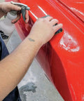 Using Pro Grade Wet Dry Sandpaper Kit With 5 Sheets Of 9x3.6 Inch Waterproof Grit For Car and Metal Use on a red car surface