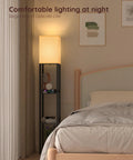 Shelf Floor Lamp With Solid Wood Shelves And USB Charging Ports in bedroom next to bed, matte black finish, glowing warm light