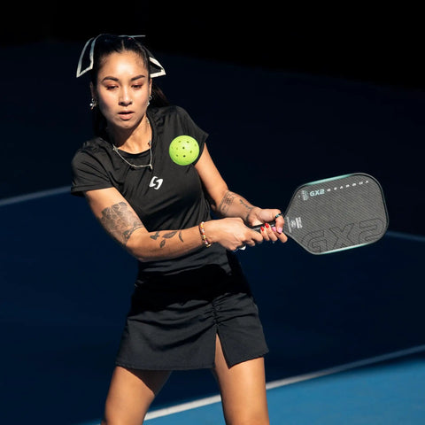Person playing pickleball with GX2 Hyper Pickleball Paddle With Aerodynamic Hyper Shape And SST 2.0 Carbon Core For Explosive Speed Spin And Precision