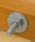 Stainless steel bolt with large flat fender washer and hex nut installed on wood panel