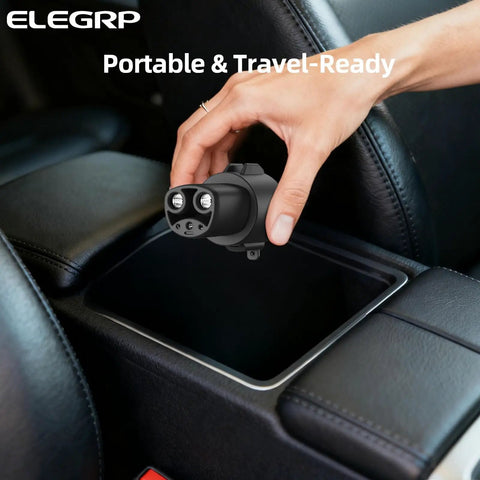 Hand holding Badass J1772 To Tesla Charging Adapter With 80 Amp Fast Plug Capability, ready for storage in car console.