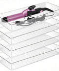 4 Pack 15x6 Inch Extra Large Clear Plastic Drawer Organizer Trays stacked with a curling iron on top for storage solutions