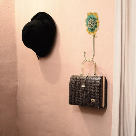 Sweet Vintage Flower Wall Hooks That Are Dang Handy For Hanging Coats Keys And Kitchen Towels Without Taking Up Valuable Space Plus The Rustic Design Looks Totally Legit In Any Room, showcasing a black hat and purse.