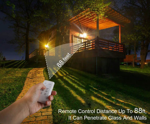 JUDYSSY 30W Led Solar Powered Flood Lights illuminating a house with remote control operation up to 88 feet, night setting.