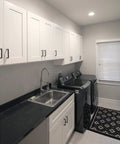 36 Inch White Corner Kitchen Cabinet With Dual Lazy Susan Spin Shelves And Smooth Operator Soft Close Doors Big Time Storage Solutions No Nonsense Daily Setup in laundry room with black countertop.