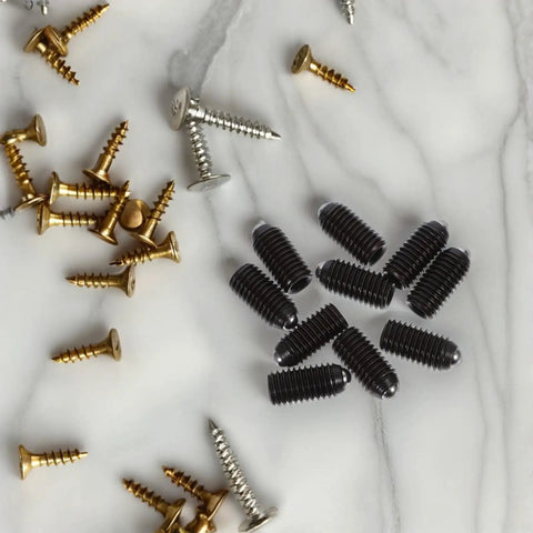 Ten Piece Heavy Duty Carbon Steel Ball Plunger Screws Featuring Internal Hex Quick Setup Design For Lock Tight Bead Positioning And No Fuss Mounting Black Hardware Collection on marble surface.