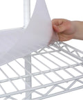 Hand placing a cover on a Seven Tier Heavy Duty Wire Shelving Unit With Wheels Adjustable Metal Rolling Rack for Garage Kitchen Pantry.