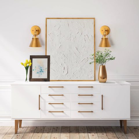 Antique Gold Wall Sconce Lighting Fixture With Modern Vintage Vibe mounted above a white sideboard in a living room setting