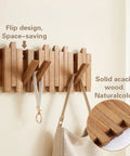 Premium Acacia Wood Wall Mounted Coat Rack With Eight Retractable Hooks, Space Saving Flip Down Entryway Stand, Zero Drama Install And Heavy Duty Grip For The Daily Grind with folded hooks and a bag.