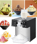 Commercial Electric Ice Shaver Machine With Adjustable Thickness For Snow Cones Slushies Smoothies Milk Tea And Bar Cocktails Stainless Steel Durable And Easy To Clean producing shaved ice with assorted desserts in background.
