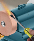 Close-up of Badass Mini Bench Grinder For Sharpening And Polishing Metal Tools, showcasing coarse wheel and tool in use.