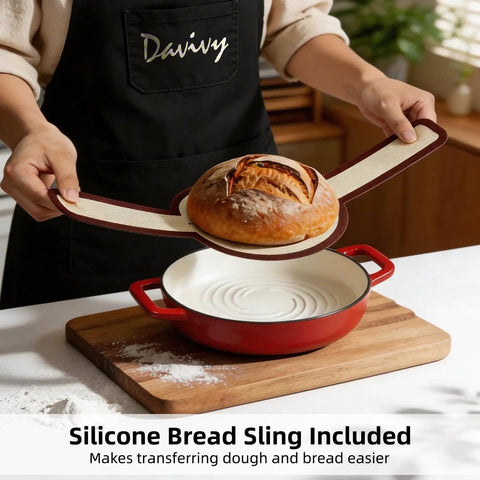 5 Quart Cast Iron Dutch Oven For Sourdough Baking With Domed Enamel Lid Round Bread Oven In Cherry Red Includes Silicone Bread Sling Perfect For Crusty Boules And Artisan Loaves, demonstrating silicone bread sling use with a baked loaf.