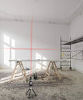 DIY Multipurpose Laser Level Tool Kit With Line Laser And Triangle Bracket projecting cross lines on wall in construction setting.