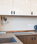 Modern kitchen with 10 Pack Black Square Bar Cabinet Knobs 2 Inch Matte Black Single Hole Kitchen Cabinet Pulls on white cabinets.