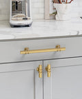 Top Shelf Ten Pack Champagne Bronze Cabinet Pulls Knockout 5 Inch Knurled Drawer Handle mounted on grey kitchen cabinets.