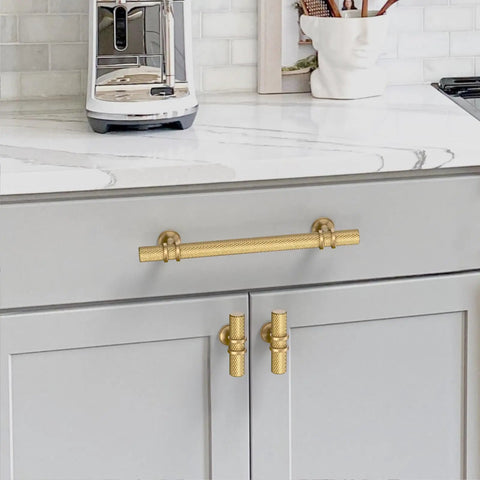 Top Shelf Ten Pack Champagne Bronze Cabinet Pulls Knockout 5 Inch Knurled Drawer Handle mounted on grey kitchen cabinets.
