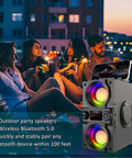 Beast Mode 40W Portable Bluetooth Speaker with Colorful Lights at an outdoor party, showing dual subwoofers and heavy bass