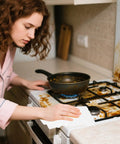 Woman using heavy duty kitchen cleaning wipes for microwave air fryer stove and cooktops all purpose appliance cleaner cloths