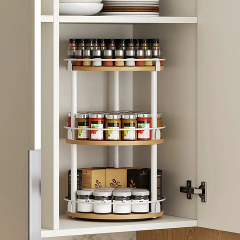 Three Tier Lazy Susan Rotating Spice Rack Featuring Smooth Ball Bearing Turntable System For Hassle Free Pantry Access White Natural Wood Countertop Organizer with spices inside a cabinet.