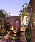 Top Tier Vintage Outdoor Wall Lantern With Brushed Brass Gooseneck And Sleek Black Aluminum Frame, illuminated in garden.
