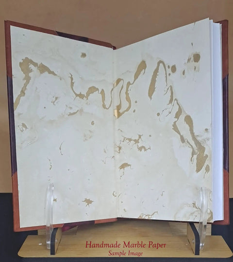 Open book showing handmade marble paper, related to Direct And General Support Maintenance Repair Parts And Special Tools Lists leather bound edition.