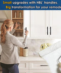 Woman installing Matte Black 3 Inch Center To Center Cabinet Pulls Set Of 30 Stainless Steel Kitchen Handles on white cabinets.