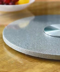 Top Shelf Heavy Duty Tempered Glass Lazy Susan Turntable close-up on wooden table, showcasing smooth surface and stainless steel bearing.