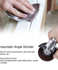 Tough As Nails Pneumatic Angle Grinder For Lightning Fast Paint Stripping And Smooth Finishing cradled in hand using sanding pad on surface.