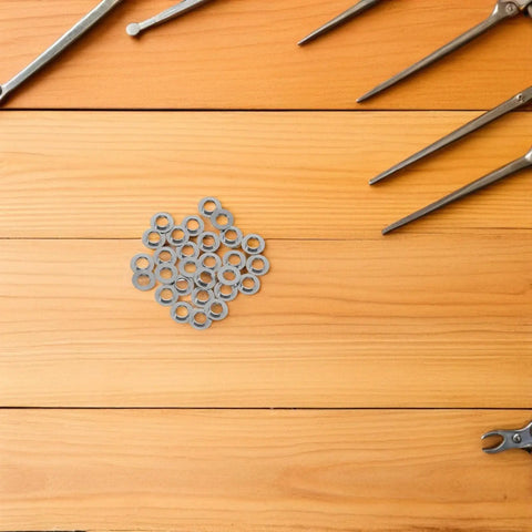 Heavy Duty Stainless Steel Eyeglass Hinge Shims Provide Dead Nuts Secure Support For Rimless Glasses Repair arranged on wooden surface.