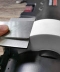 Close-up of Low Speed Knife Sharpener With Wet And Dry Grinding Wheel 0.7 Amp, showing metal blade against grinding wheel.