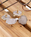 White Geode Cabinet Knobs 4 Pack Gold Plated Gemstone Drawer Pulls Crystal Cupboard Handles Kitchen Decorative Hardware Set close-up on wooden surface.