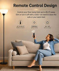 Woman using remote control for Remote Control Torchiere Floor Lamp With Stepless Dimming And Color Temperature in living room.